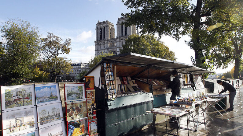 Des bouquinistes installent leurs stands sur la promenade au-dessus de la Seine, près de la cathédrale Notre-Dame. (Photo FRANCOIS GUILLOT/AFP via Getty Images)