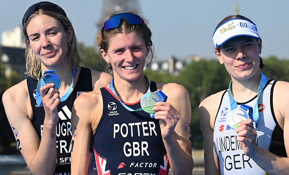 L'Anglaise Beth Potter (au c.), première, la Française Cassandre Beaugrand (à g.), deuxième, et l'Allemande Laura Lindemann (à dr.), troisième, célèbrent leur victoire sur le podium à l'issue d'une épreuve test de triathlon féminin pour les prochains Jeux Olympiques de 2024 à Paris, le 17 août 2023. (Photo BERTRAND GUAY/POOL/AFP via Getty Images)