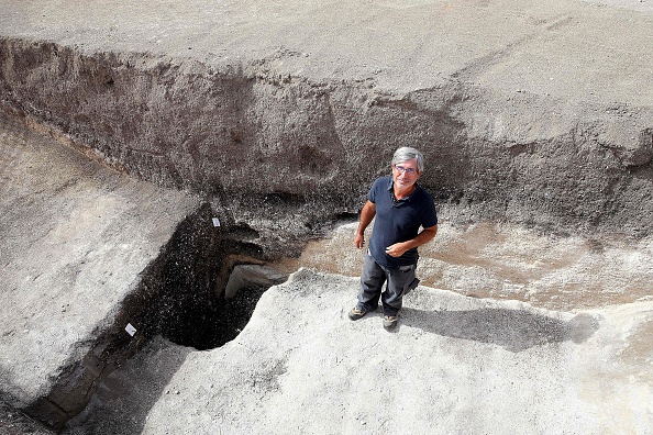 Rémi Martineau, chercheur au CNRS, à l'entrée d'un puits datant du Néolithique moderne, vers 3500 ans, d'un habitat suggérant la présence d'un village occupé par une population structurée, au Val-des-Marais dans le sud de la Marne, le 23 août 2023. (Photo FRANCOIS NASCIMBENI/AFP via Getty Images)