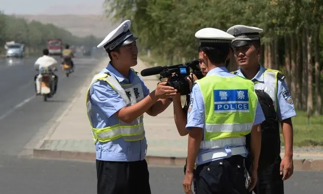 La police chinoise retient un journaliste à un poste de contrôle sur la route de la ville ouïghoure de Lukqun, dans la province du Xinjiang, le 28 juin 2013. (Mark Ralston/AFP via Getty Images)