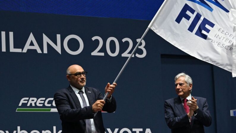 Bruno Gares (à.g), tient le drapeau de la Fédération internationale d'escrime (FIE) qui lui a été remis par le président de la FIE, le Grec Emmanuel Katsiadakis (à.d), lors de la cérémonie de clôture des Championnats du monde d'escrime de la FIE à la foire Allianz MI.CO (Milano Convegni) à Milan, le 30 juillet 2023. (Photo : ANDREAS SOLARO/AFP via Getty Images)