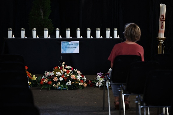 Une femme se recueille devant onze bougies pour onze victimes à Wintzenheim, le 11 août 2023. (Photo SÉBASTIEN BOZON/AFP via Getty Images)
