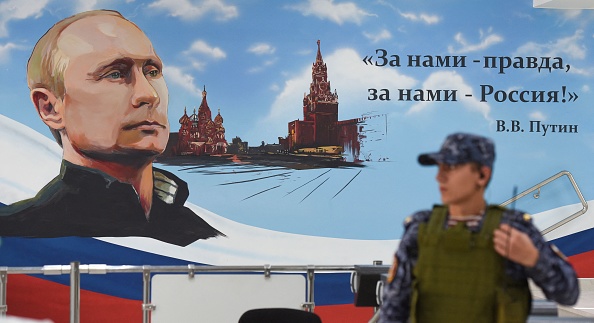 Un mur portant une image du Président russe Vladimir Poutine et du Kremlin de Moscou dans un bureau de vote lors des élections locales organisées par les autorités installées par la Russie à Donetsk, le 8 septembre 2023. (Photo AFP via Getty Images)