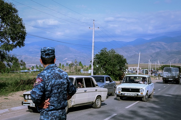 Un officier de police arménien regarde les véhicules des réfugiés à Kornidzor, le 24 septembre 2023. (Photo ALAIN JOCARD/AFP via Getty Images)