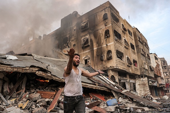 Un homme réagit à l'extérieur d'un bâtiment en flammes après un bombardement israélien dans la ville de Gaza le 11 octobre 2023. (Photo MOHAMMED ABED/AFP via Getty Images)