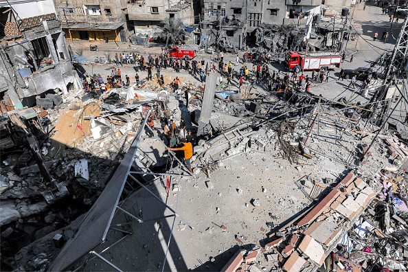 Le 31 octobre 2023, à Rafah, dans le sud de la bande de Gaza, des employés de la défense civile recherchent des victimes et des survivants dans les décombres d'un bâtiment touché par un bombardement israélien. (Photo MOHAMMED ABED/AFP via Getty Images)