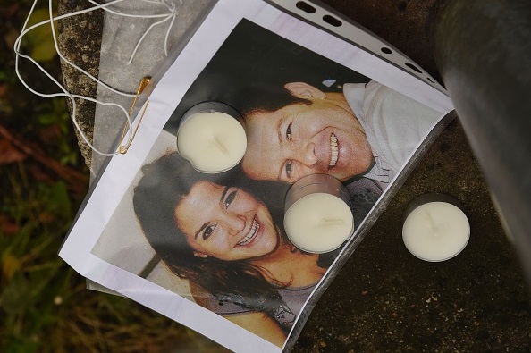 Des bougies posées sur la photo du policier français Jean-Baptiste Salvaing et de sa partenaire Jessica Schneider, qui ont été tués devant leur domicile à Magnanville, en 2016. (Photo DOMINIQUE FAGET/AFP via Getty Images)