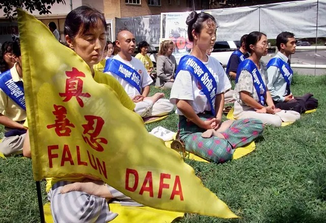 Des pratiquants de Falun Gong méditent alors qu'ils entament leur quatrième jour de grève de la faim devant l'ambassade de Chine à Washington, le 20 août 2001. Cette grève de la faim a été organisée en soutien aux 130 pratiquants de Falun Gong qui avaient entamé une grève de la faim dans le camp de travail de Masanjia, pour protester contre leur détention injuste et les traitements brutaux qu'ils subissaient dans le camp. (Stephen Jaffe/AFP/Getty Images)