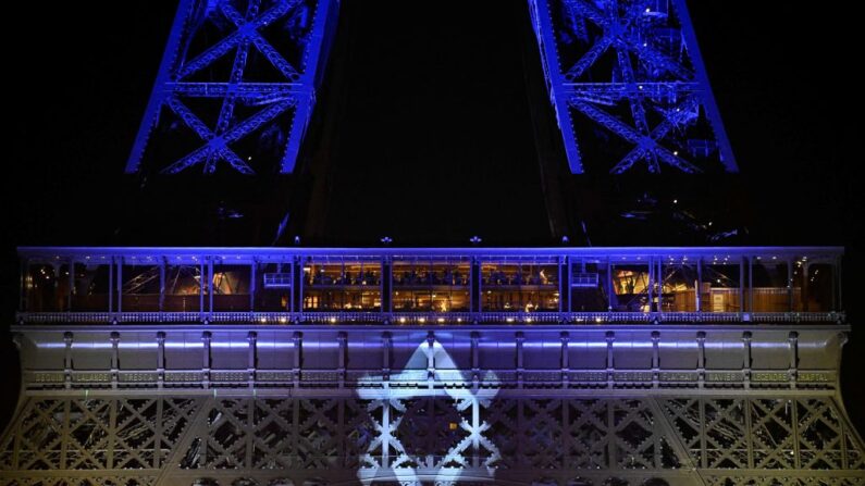 Cette photographie prise le 9 octobre 2023 montre la Tour Eiffel illuminée de l'étoile de David et des couleurs du drapeau national d'Israël, en hommage aux victimes des récents attentats du Hamas. (Photo de JULIEN DE ROSA/AFP via Getty Images)