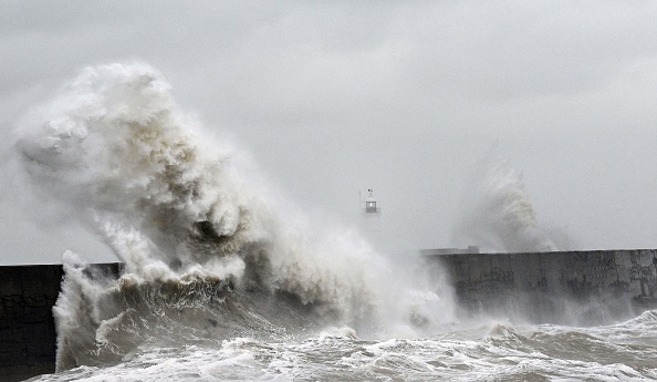 Des vagues s'abattent sur le phare de Newhaven et le mur du port à Newhaven, dans le sud de l'Angleterre, le 2 novembre 2023. (Photo GLYN KIRK/AFP via Getty Images)