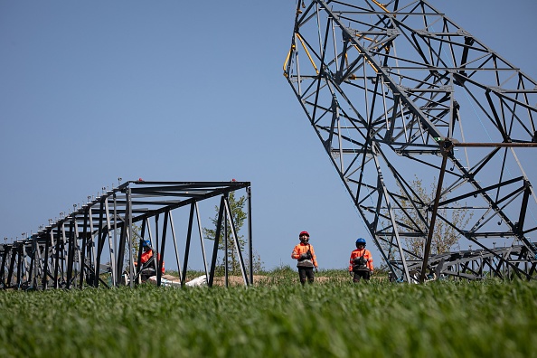 Des employés travaillent sur le transport de pylônes électriques pendant les travaux de rénovation des lignes à haute tension par le gestionnaire du réseau électrique RTE, près de Flers. (Photo LOU BENOIST/AFP via Getty Images)