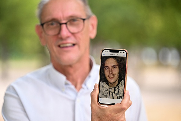 Paul Raoult, le père de Sébastien Raoult, montre un téléphone avec un portrait de son fils à Épinal, France. (Photo JEAN-CHRISTOPHE VERHAEGEN/AFP via Getty Images)