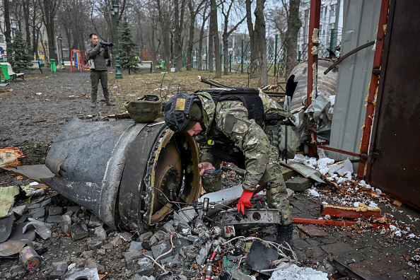 Un expert militaire ukrainien examine les débris à l'extérieur d'un immeuble résidentiel endommagé dans le centre de Kharkiv après un tir de missile le 2 janvier 2024. (Photo SERGEY BOBOK/AFP via Getty Images)