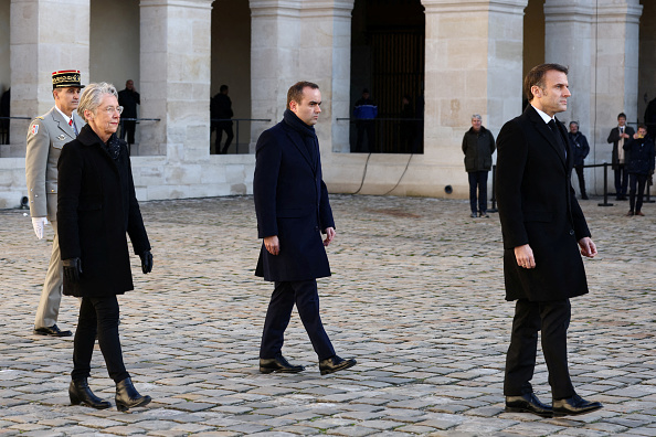 Le président Emmanuel Macron, suivi du ministre français des Armées Sébastien Lecornu et de la Première ministre Elisabeth Borne, à l'Hôtel des Invalides à Paris, le 5 janvier 2024. (STEPHANIE LECOCQ/POOL/AFP via Getty Images)