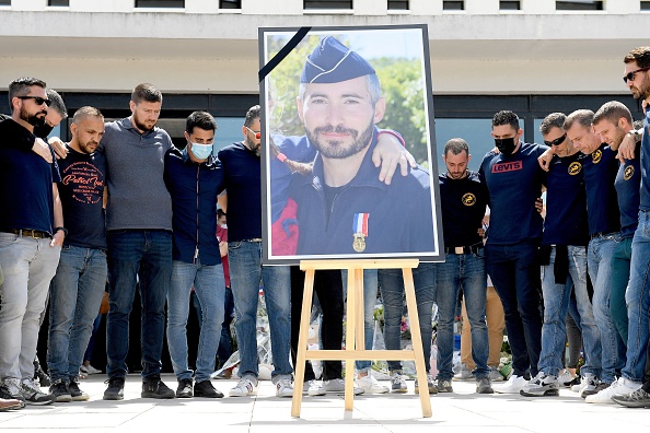 Des policiers se rassemblent autour du portrait de leur collègue Éric Masson au commissariat principal d'Avignon, le 9 mai 2021, pour lui rendre hommage. (Photo NICOLAS TUCAT/AFP via Getty Images)