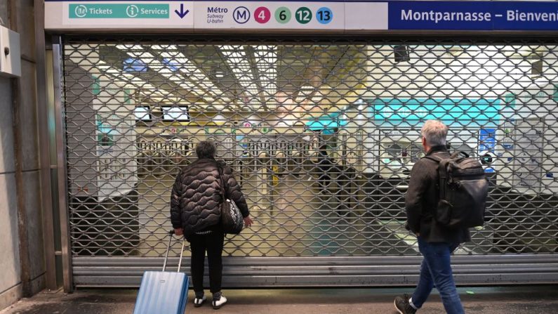 Des passagers attendent devant une grille fermée de la station de métro Gare Montparnasse lors d'une grève à Paris le 10 novembre 2022 (ALAIN JOCARD/AFP via Getty Images)