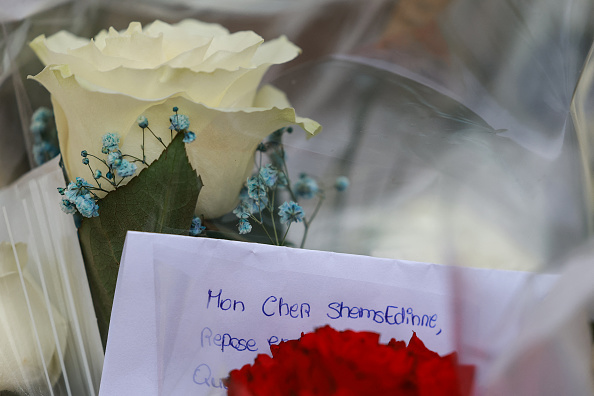 Des fleurs et une lettre portant l'inscription « Mon cher Shemsedinne » exposées en hommage devant l'entrée du collège Les Sablons à Viry-Châtillon. (Photo EMMANUEL DUNAND/AFP via Getty Images)