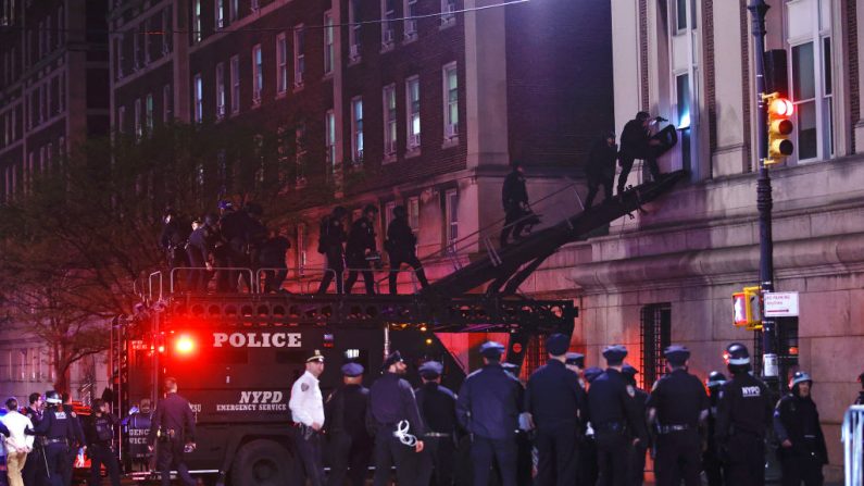 Des agents de la police de New York en tenue anti-émeute pénètrent dans un bâtiment de l'université Columbia, où des étudiants pro-palestiniens se sont barricadés et ont installé un campement, à New York, le 30 avril 2024.(KENA BETANCUR/AFP via Getty Images)