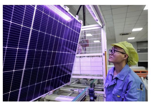 Un ouvrier observe la fabrication des modules photovoltaïques utilisés pour les panneaux solaires dans une usine de la ville de Huaian, dans la province chinoise du Jiangsu, le 25 septembre 2023. (STR/AFP via Getty Images)