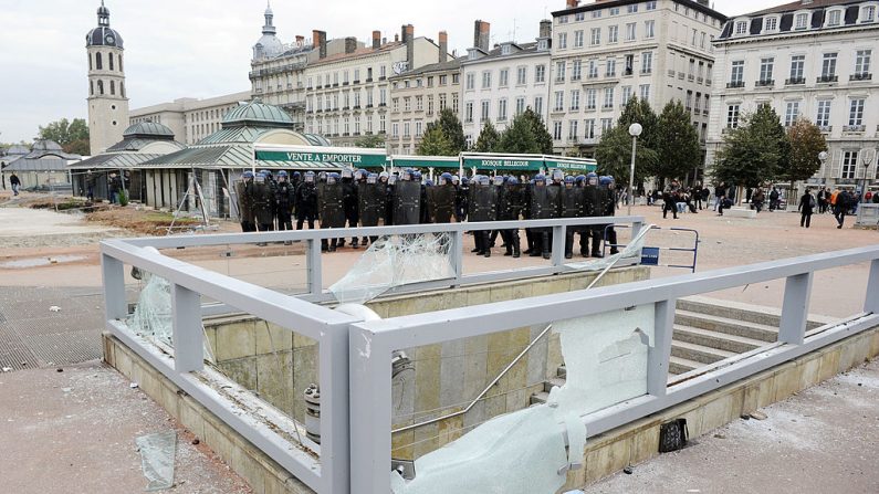 Des policiers anti-émeutes montent la garde près d'une entrée de métro, totalement dévastée, le 19 octobre 2010 à Lyon après une manifestation de protestation contre la réforme des retraites du gouvernement français. 
(Photo read PHILIPPE DESMAZES/AFP via Getty Images)