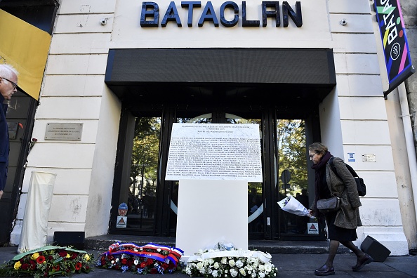 Une femme dépose des fleurs devant une plaque commémorative lors d'une cérémonie au Bataclan à Paris le 13 novembre 2022. (Photo JULIEN DE ROSA/AFP via Getty Images)