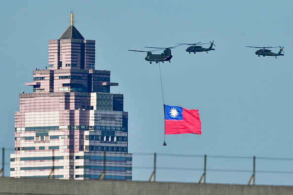 Un hélicoptère américain CH-47SD fait flotter un drapeau national devant un bâtiment lors d'une répétition avant la cérémonie d'investiture du président élu taïwanais Lai Ching-te, le 15 mai 2024 à Taipei. (SAM YEH/AFP via Getty Images)