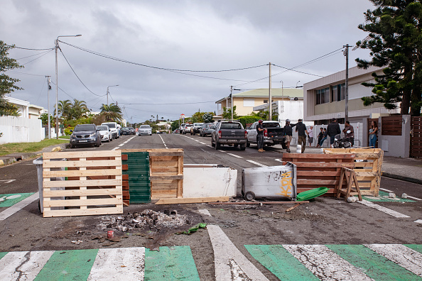 Des résidents se tiennent près d'un barrage routier qu'ils ont mis en place pour bloquer l'accès et canaliser les militants indépendantistes à l'entrée de Tuband, à Nouméa. (Photo DELPHINE MAYEUR/AFP via Getty Images)