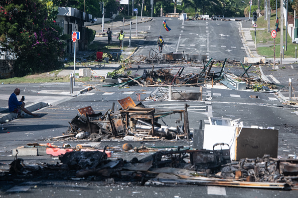 Une rue bloquée par des débris et des objets brûlés après une nuit de troubles dans le quartier de Magenta à Nouméa, en Nouvelle-Calédonie. (Photo DELPHINE MAYEUR/AFP via Getty Images)