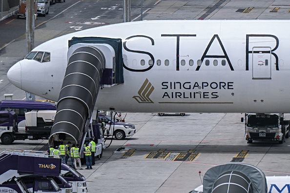 Des officiels entrent dans l'avion Boeing 777-300ER de Singapore Airlines sur le tarmac de l'aéroport international Suvarnabhumi de Bangkok, le 22 mai 2024. (Photo LILLIAN SUWANRUMPHA/AFP via Getty Images)