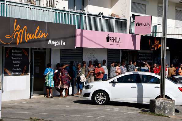 Des personnes font la queue pour acheter du pain dans le quartier de Magenta, à Nouméa. (Photo LUDOVIC MARIN/POOL/AFP via Getty Images)
