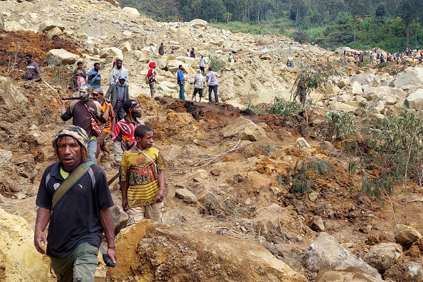 Des habitants se rassemblent sur le site d'un glissement de terrain au village de Mulitaka, en Papouasie-Nouvelle-Guinée, le 26 mai 2024. (Photo STR/AFP via Getty Images)