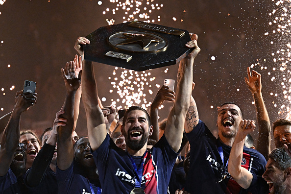 L'arrière central du PSG Nikola Karabatic (au c.) et ses coéquipiers célèbrent leur 10e titre de champion de France, à Paris le 31 mai 2024. (Photo JULIEN DE ROSA/AFP via Getty Images)