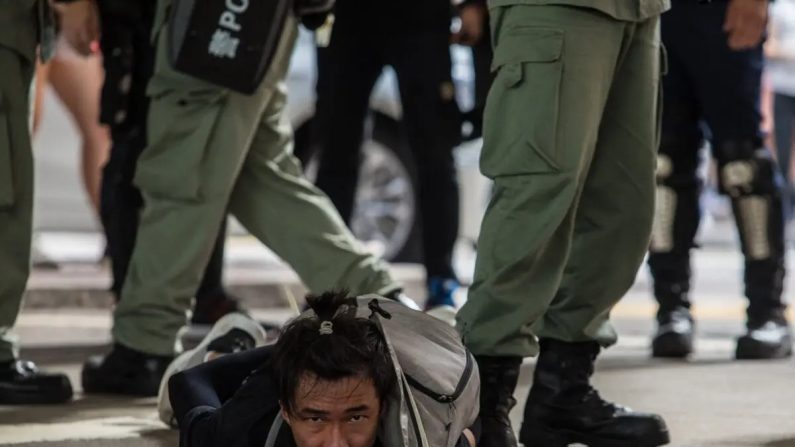La police anti-émeute arrête un homme alors qu'elle chasse les manifestants qui participent à un rassemblement contre une nouvelle loi sur la sécurité nationale à Hong Kong, le 1er juillet 2020, à l'occasion du 23e anniversaire de la rétrocession de la ville de la Grande-Bretagne à la Chine. (Dale De La Rey/AFP via Getty Images)