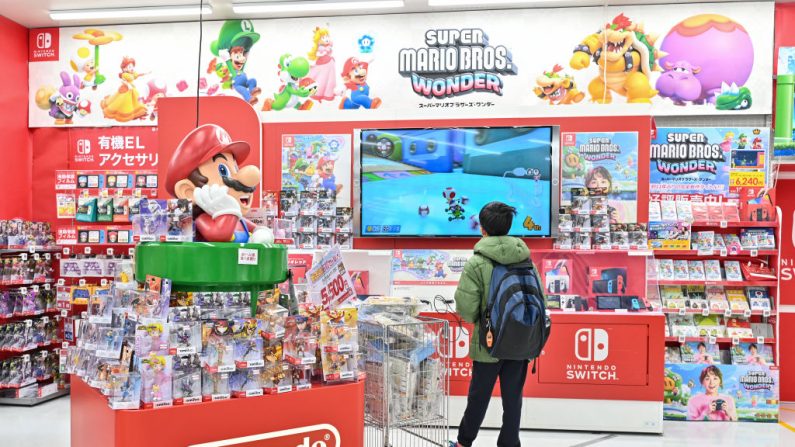Un jeune client regarde un présentoir de Super Mario de la société japonaise de jeux Nintendo, dans un magasin d'électronique à Tokyo. (RICHARD A. BROOKS/AFP via Getty Images)