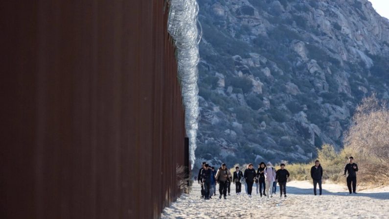 Des immigrants clandestins qui sont passés par une brèche dans le mur frontalier américain attendent d'être traités par des agents de la patrouille des frontières à Jacumba, en Californie, le 7 décembre 2023. (John Fredricks/Epoch Times)