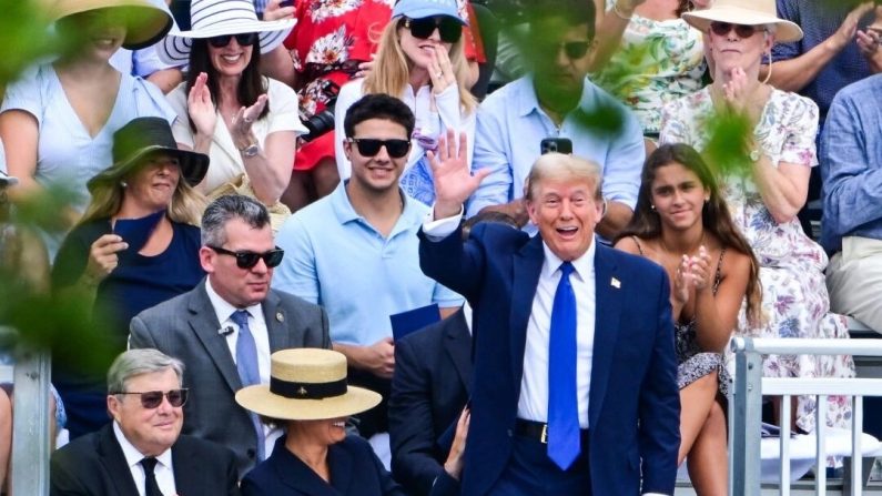 L'ancien président Donald Trump salue la foule alors qu'il assiste à la cérémonie de remise des diplômes de son fils, Barron Trump, à l'Académie Oxbridge à Palm Beach (Floride), le 17 mai 2024. (Giorgio Viera/AFP via Getty Images)
