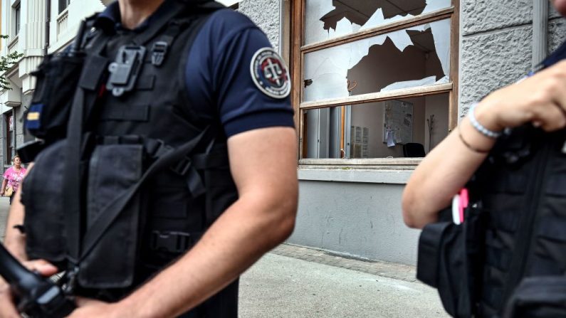 Il y un an, des policiers français se tenaient devant un commissariat endommagé à Lyon, le 1er juillet 2023, après une quatrième nuit consécutive d'émeutes en France suite au meurtre d'un adolescent par la police. (Crédit photo OLIVIER CHASSIGNOLE/AFP via Getty Images)