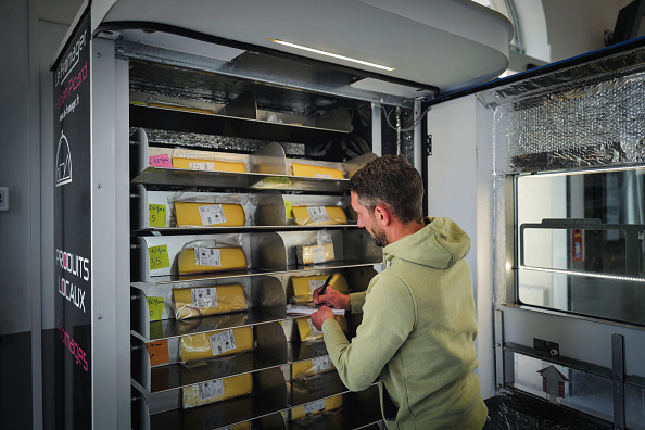 Le fromager Fabien Picard remplit son distributeur de fromage à la gare de Bourg en Bresse. (OLIVIER CHASSIGNOLE/AFP via Getty Images)