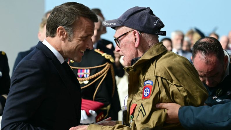 Le président français Emmanuel Macron remet la Légion d'Honneur au vétéran américain Joseph Miller pendant les cérémonies commémoratives du 80e anniversaire du D-Day, le 6 juin 2024 sur la plage de Omaha Beach (Calvados). (Crédit photo MIGUEL MEDINA/AFP via Getty Images)