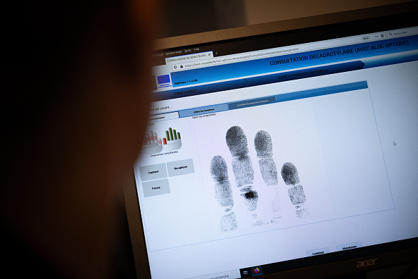 Un agent de la police scientifique examine une empreinte digitale au Service interdépartemental de la police judiciaire (SIPJ) à Rouen. (LOU BENOIST/AFP via Getty Images)