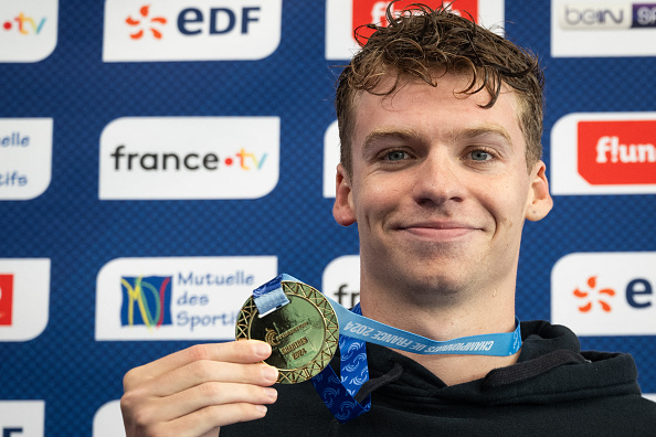 Léon Marchand sur le podium après avoir remporté la finale du 200 m papillon lors des championnats de France de natation à Chartres, le 19 juin 2024. (Photo SEBASTIEN BOZON/AFP via Getty Images)