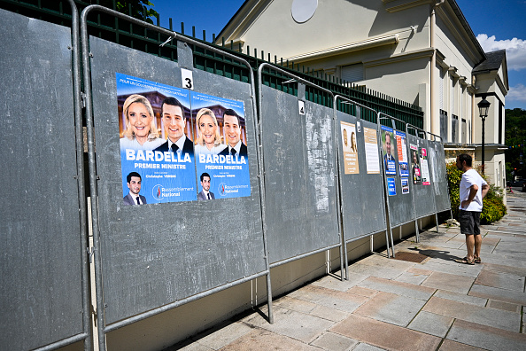Un homme regarde les panneaux électoraux avec différents candidats, au Plessis Robinson, le 24 juin 2024. (MAGALI COHEN/Hans Lucas/AFP via Getty Images)