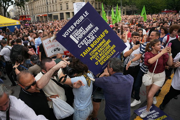 Des membres du collectif Némésis portant des pancartes anti-NFP violemment agressés par des manifestants lors d'un rassemblement anti RN, place de la République à Paris, le 27 juin 2024. (ZAKARIA ABDELKAFI/AFP via Getty Images)
