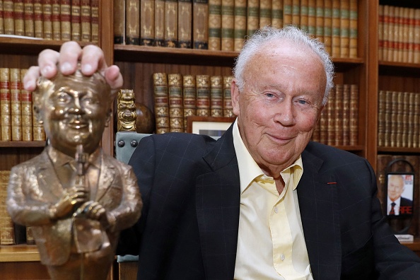 Philippe Bouvard pose avec une statue miniature de lui-même dans sa maison à Paris, le 31 août 2016. (Photo PATRICK KOVARIK/AFP via Getty Images)