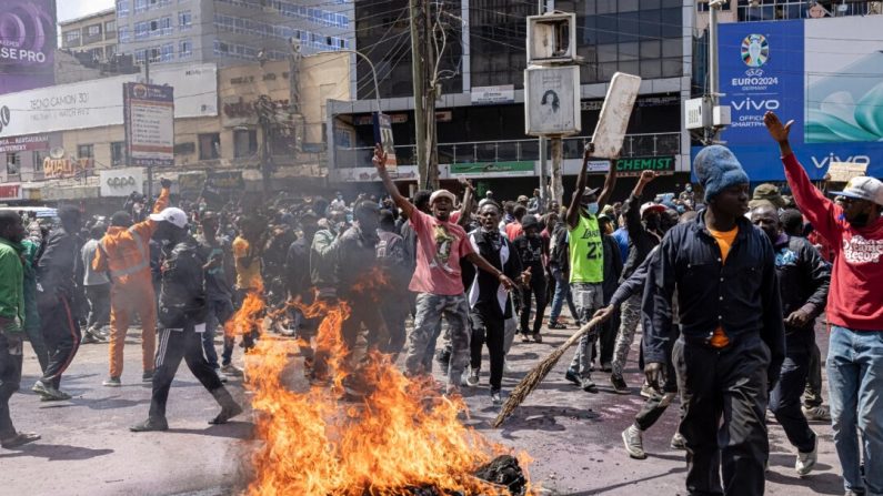 Des manifestants réagissent devant des pneus enflammés lors d'une manifestation contre le projet de loi de finances à Nairobi, au Kenya, le 25 juin 2024. (Patrick Meinhardt/Getty Images)