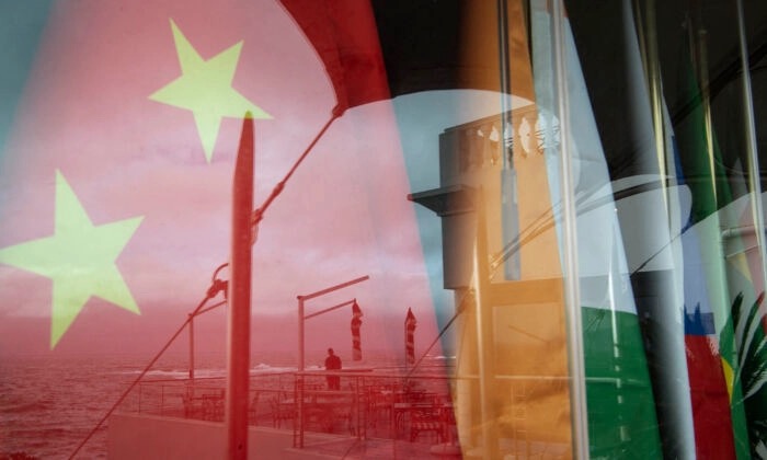 Vue d'un reflet sur une fenêtre d'un homme regardant la mer devant les drapeaux nationaux des pays du BRICS (Chine, Inde, Russie, Afrique du Sud, Brésil) lors de la réunion des ministres des Affaires étrangères des BRICS au Cap, le 2 juin 2023. (Rodger Bosch/AFP via Getty Images)