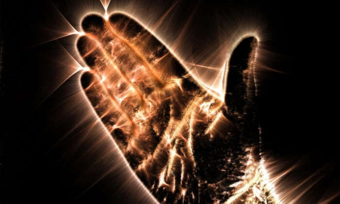 La photographie de l'aura Kirlian montre une main humaine rayonnante. (MP_Foto/Shutterstock)
