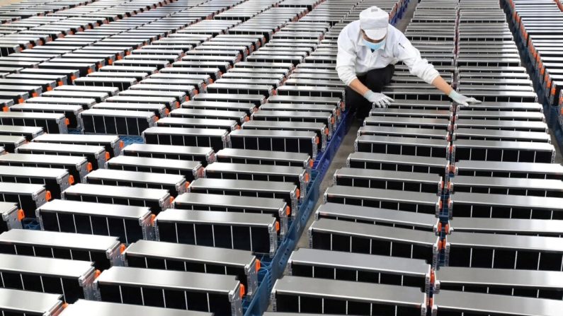 Un ouvrier manipule des batteries de voiture dans une usine de Xinwangda Electric Vehicle Battery Co. Ltd, qui fabrique des batteries au lithium pour les voitures électriques et d'autres utilisations, à Nanjing, dans la province chinoise du Jiangsu (Est), le 12 mars 2021. (STR/AFP via Getty Images)