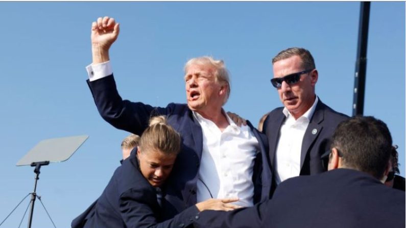 Donald Trump avec du sang sur le visage, entouré d'agents des services secrets, lors de son rassemblement électoral à Butler, en Pennsylvanie, le 13 juillet 2024. (Anna Moneymaker/Getty Images)