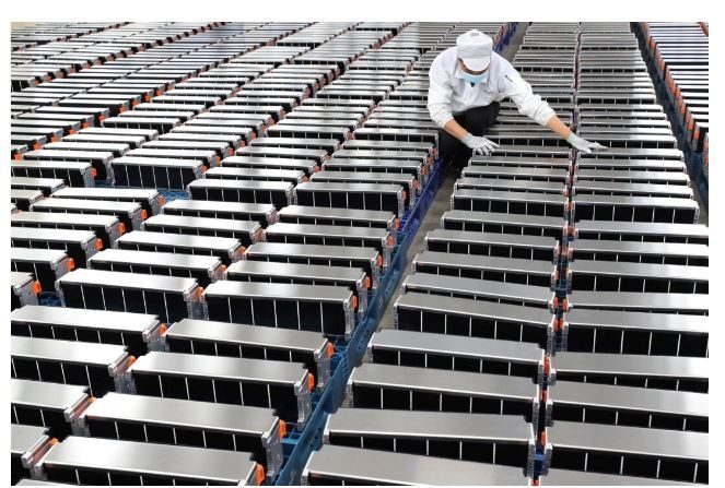 Un ouvrier travaille avec les batteries au lithium pour les voitures électriques dans une usine à Nanjing, dans la province chinoise du Jiangsu, le 12 mars 2021. (STR/AFP via Getty Images)